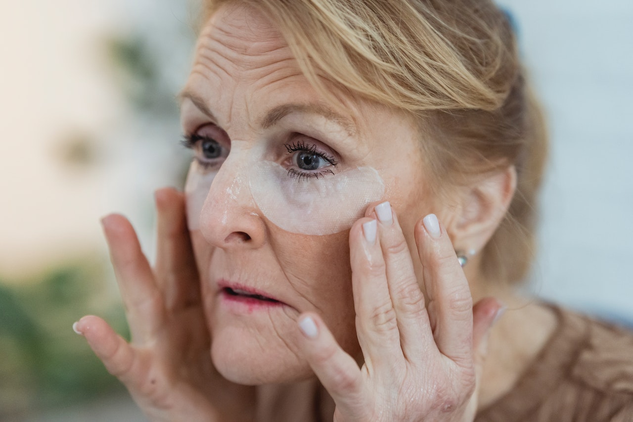 An older woman with collagen eye patches